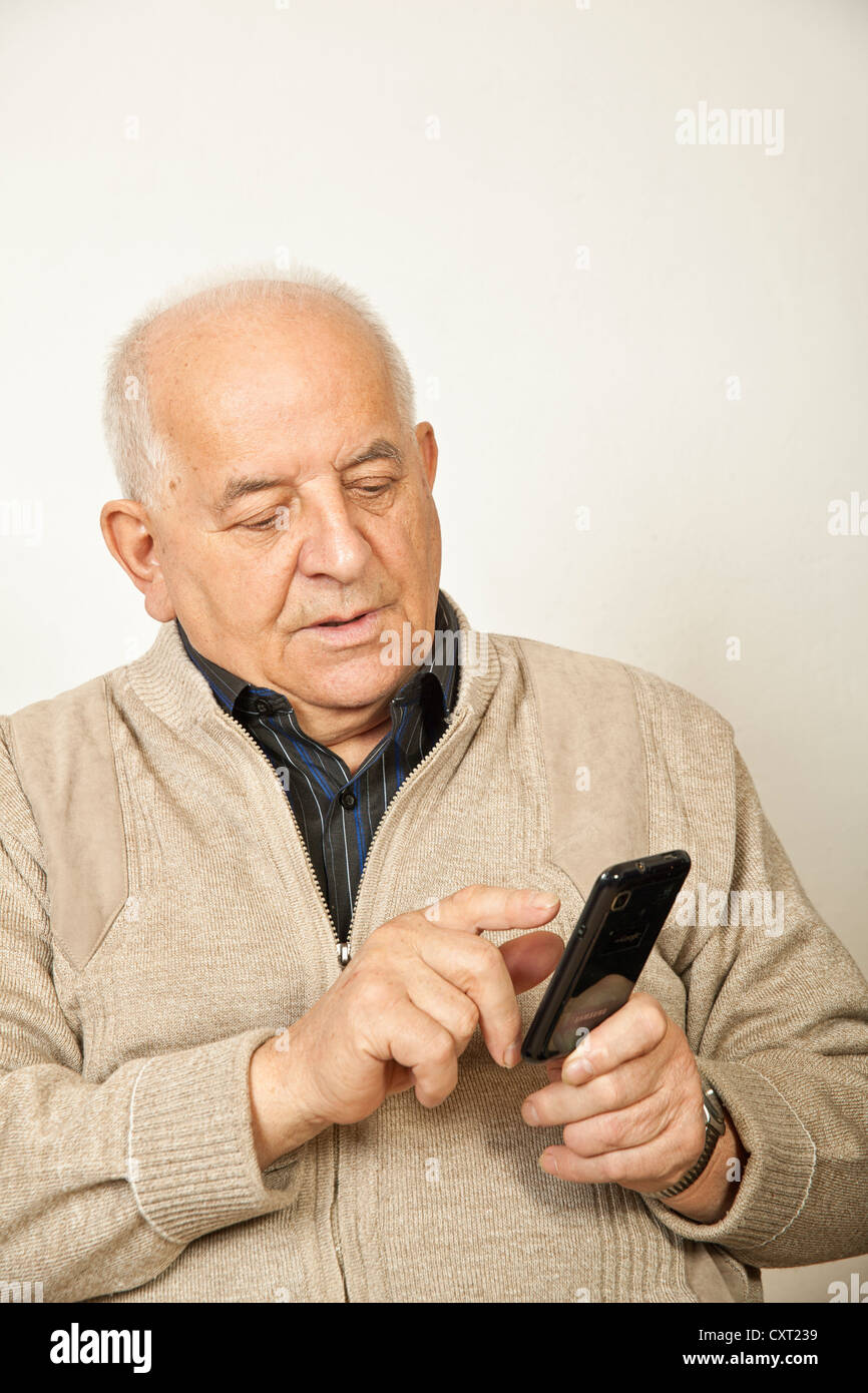 Uomo vecchio con uno smartphone Foto Stock
