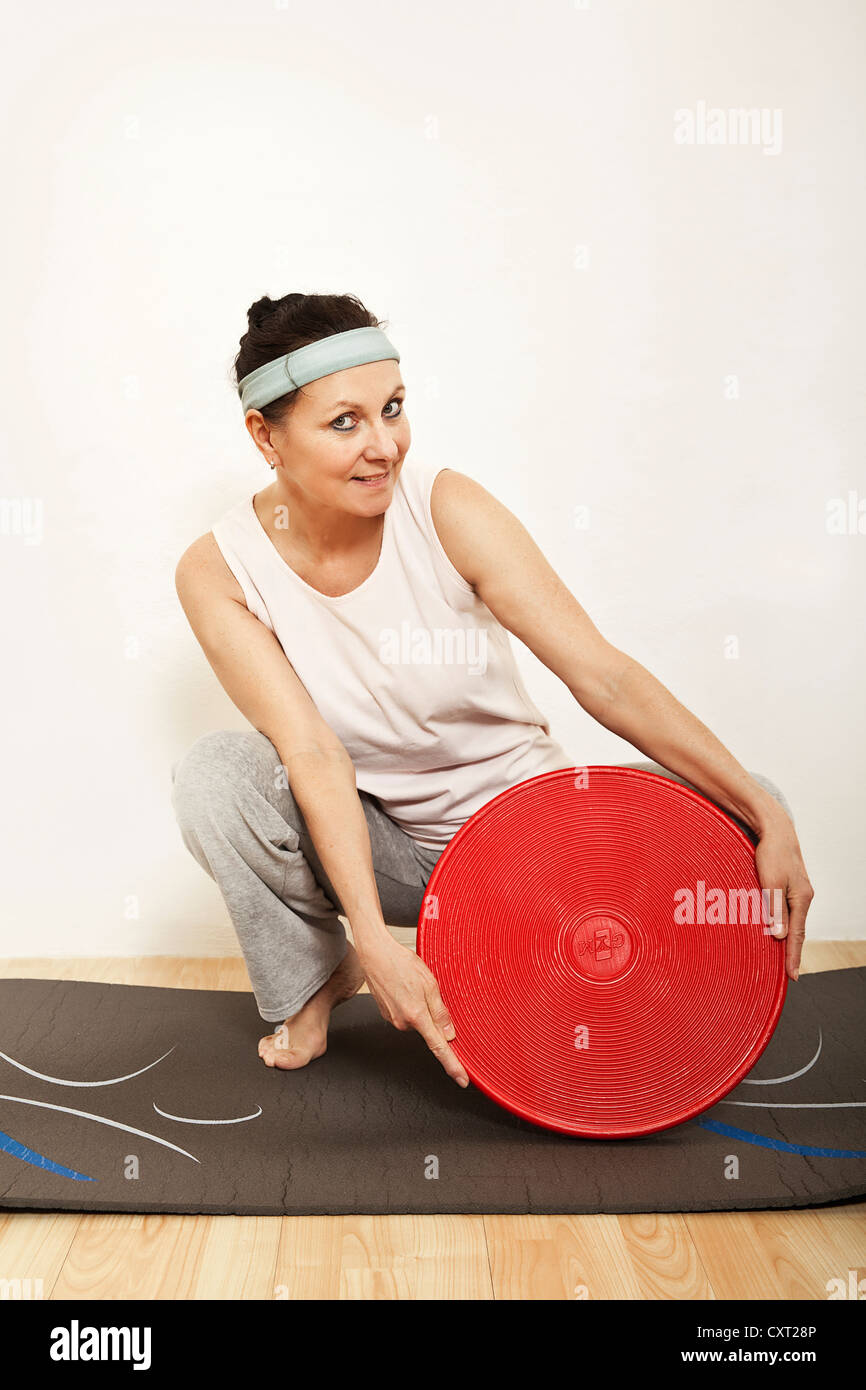 Donna che esercitano con un Balance board, ginnastica Foto Stock