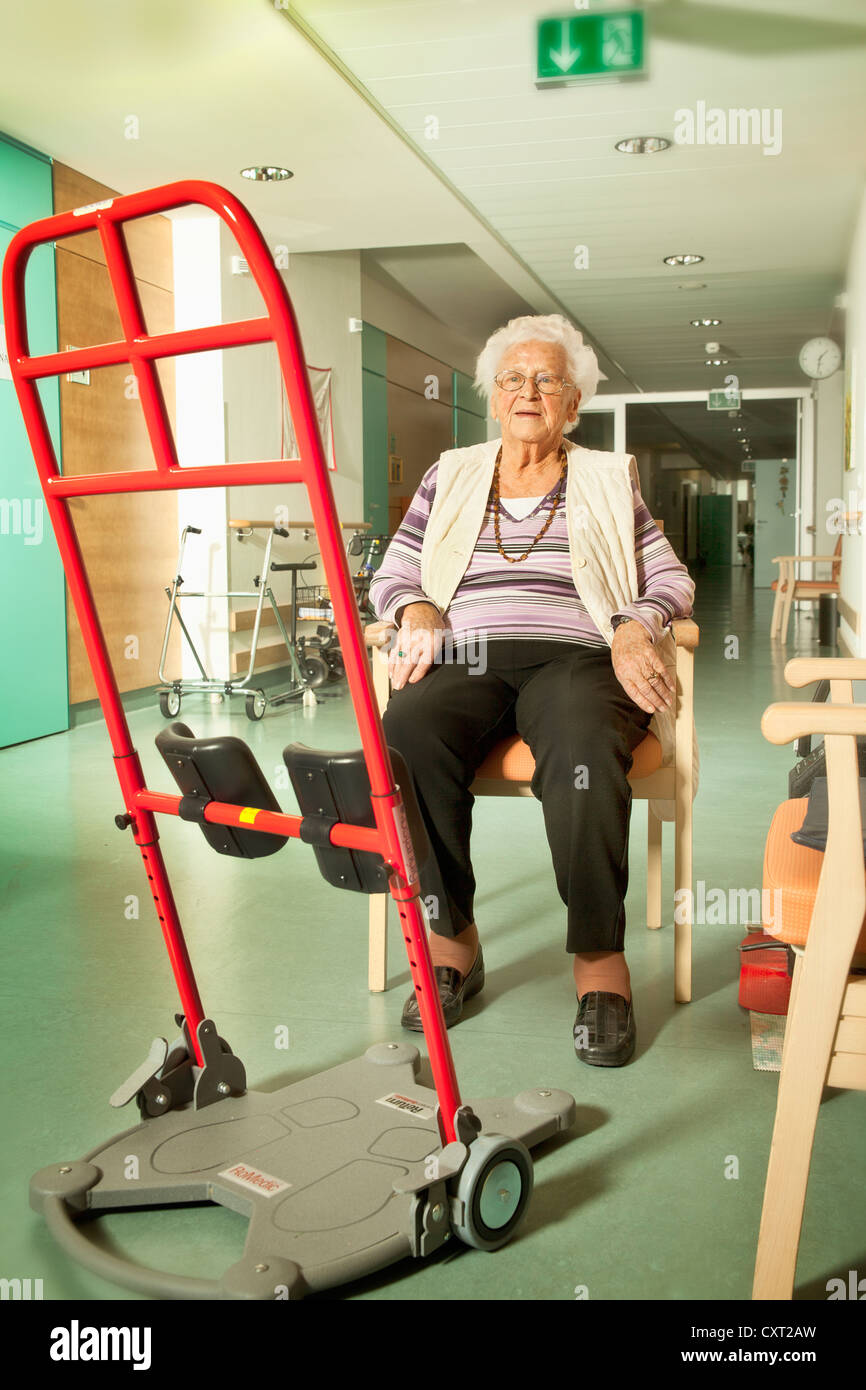 Donna anziana con un aiuto per alzarsi, la casa di cura, la riabilitazione Foto Stock
