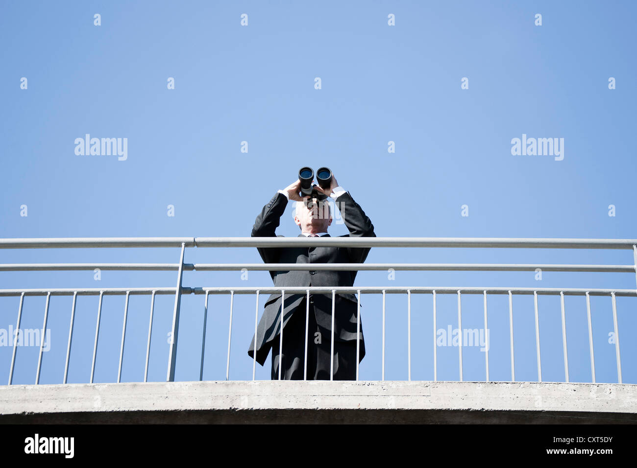 Imprenditore cerca attraverso il binocolo in distanza Foto Stock