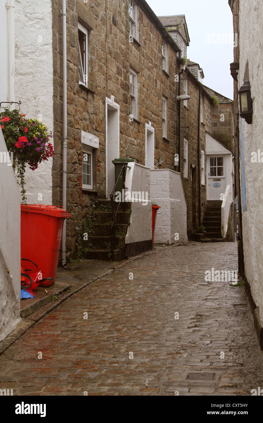 Wet back street in Cornish città di St Ives con pittoresche scene e la vecchia serie di passaggi da un cobbed superficie stradale Foto Stock