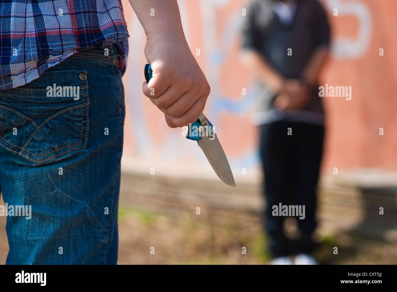 Ragazzo è minacciato da un giovane con un coltello Foto Stock