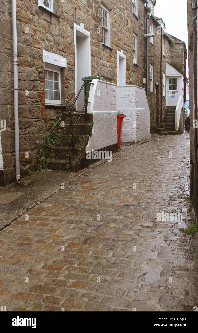 Wet back street in Cornish città di St Ives con pittoresche scene e la vecchia serie di passaggi da un cobbed superficie stradale Foto Stock
