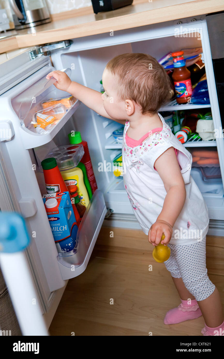 Bambina esplorando il frigo Foto Stock