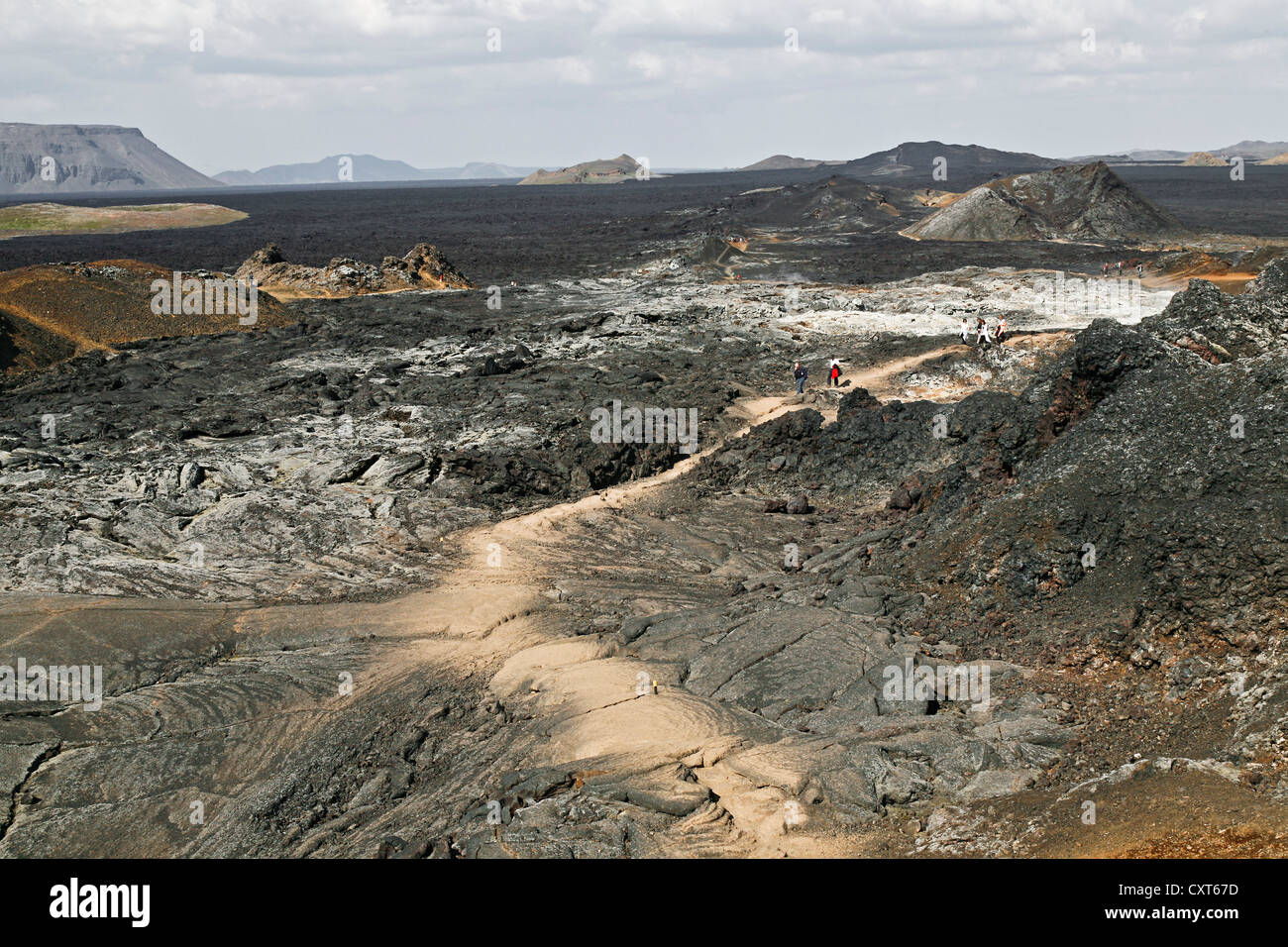 I visitatori a piedi su un percorso in un paesaggio di campi di lava e Crateri estinti e lava colorata in Leirhnjukur area geotermica Foto Stock