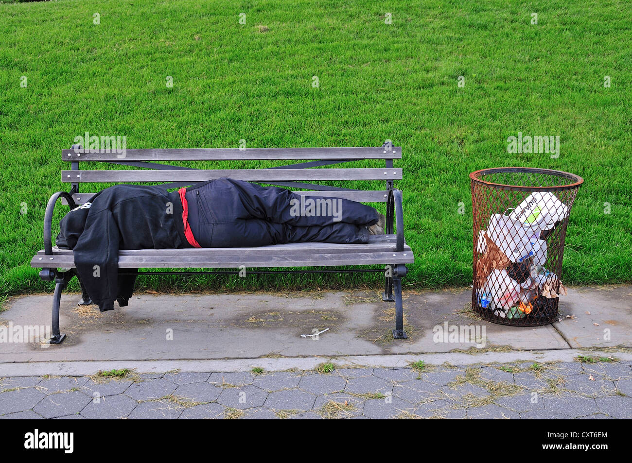 Donna senzatetto addormentato su una panchina nel parco, Manhattan, New York City, Stati Uniti d'America, America del Nord, America, PublicGround Foto Stock