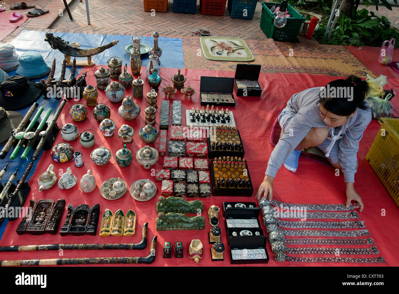 Una donna espone la sua mercanzia pronto per il mercato notturno a Luang Prabang, Laos Foto Stock