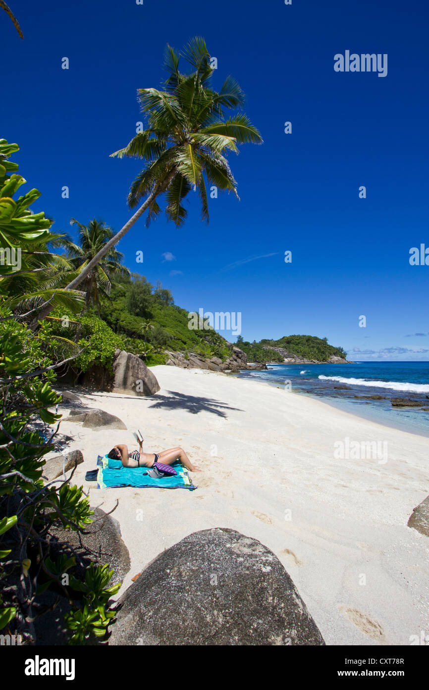 Donna sdraiata sulla spiaggia, southern Mahe, Mahe, Seychelles, Africa, Oceano Indiano Foto Stock