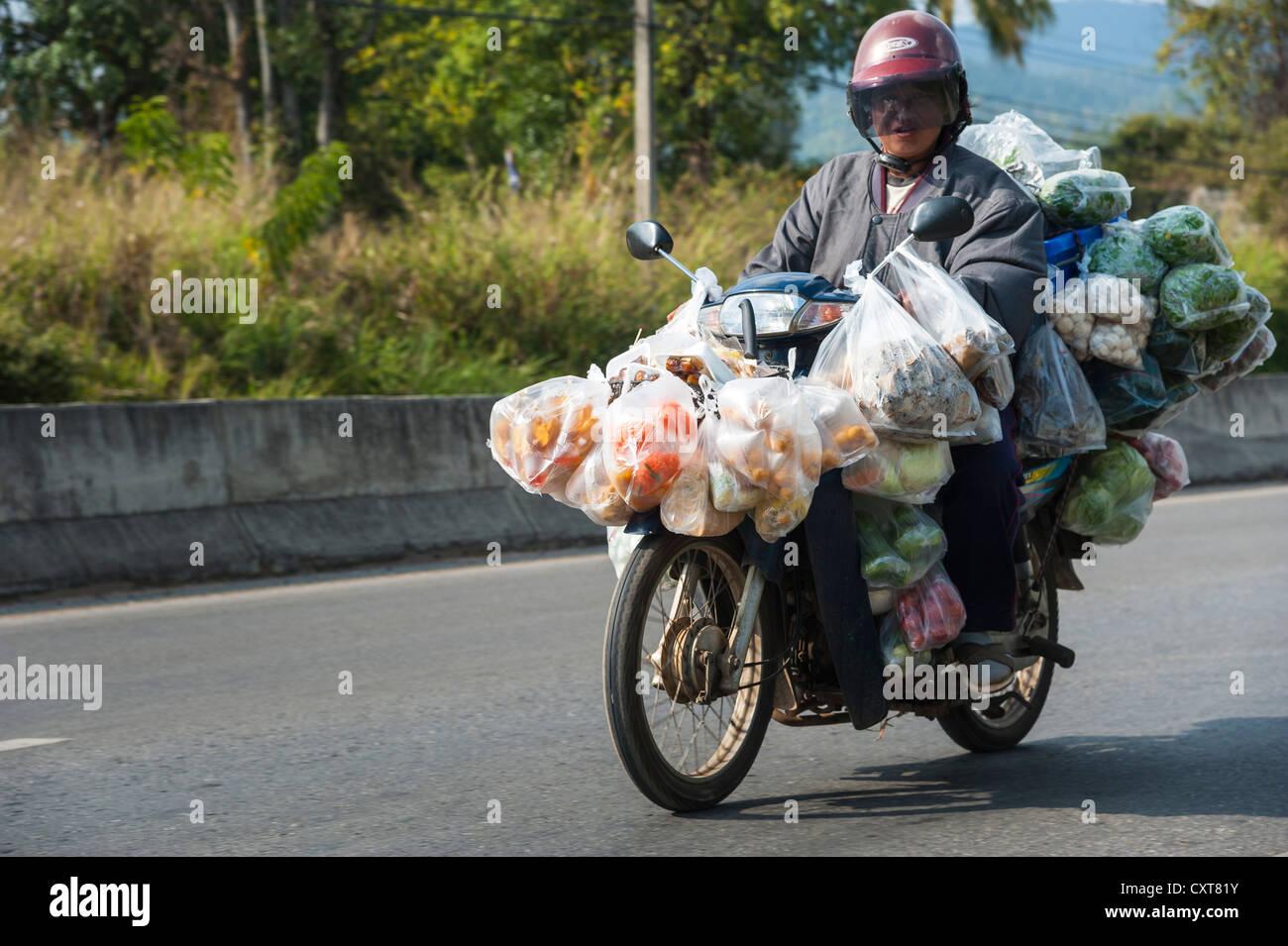 Uomo con molte borse in sella a una motocicletta a pieno carico, Thailandia del Nord della Thailandia, Asia Foto Stock