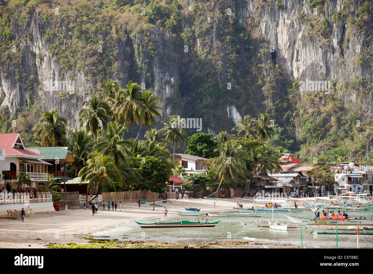 Spiaggia di sabbia e scogliere calcaree e la città di El Nido, una località turistica, PALAWAN FILIPPINE, Asia Foto Stock