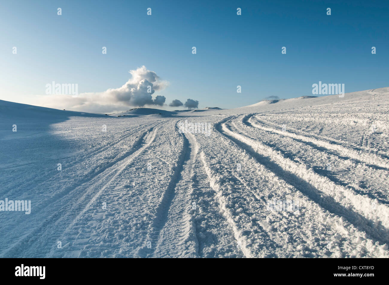 Tracce nella neve e una nuvola di fumo o di cenere dal vulcano Fimmvoerðuháls, Mýrdalsjoekull ghiacciaio, Suðurland, Sud Islanda Foto Stock