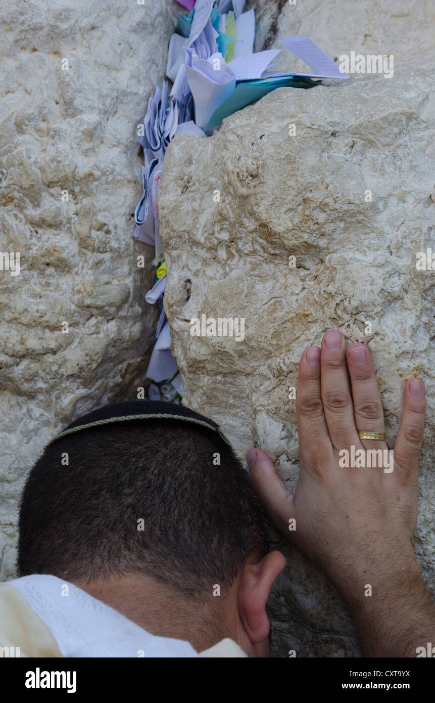 Ritratto di un ebreo in preghiera presso il Muro Occidentale con note su carta nel crack. Gerusalemme la città vecchia. Israele. Foto Stock