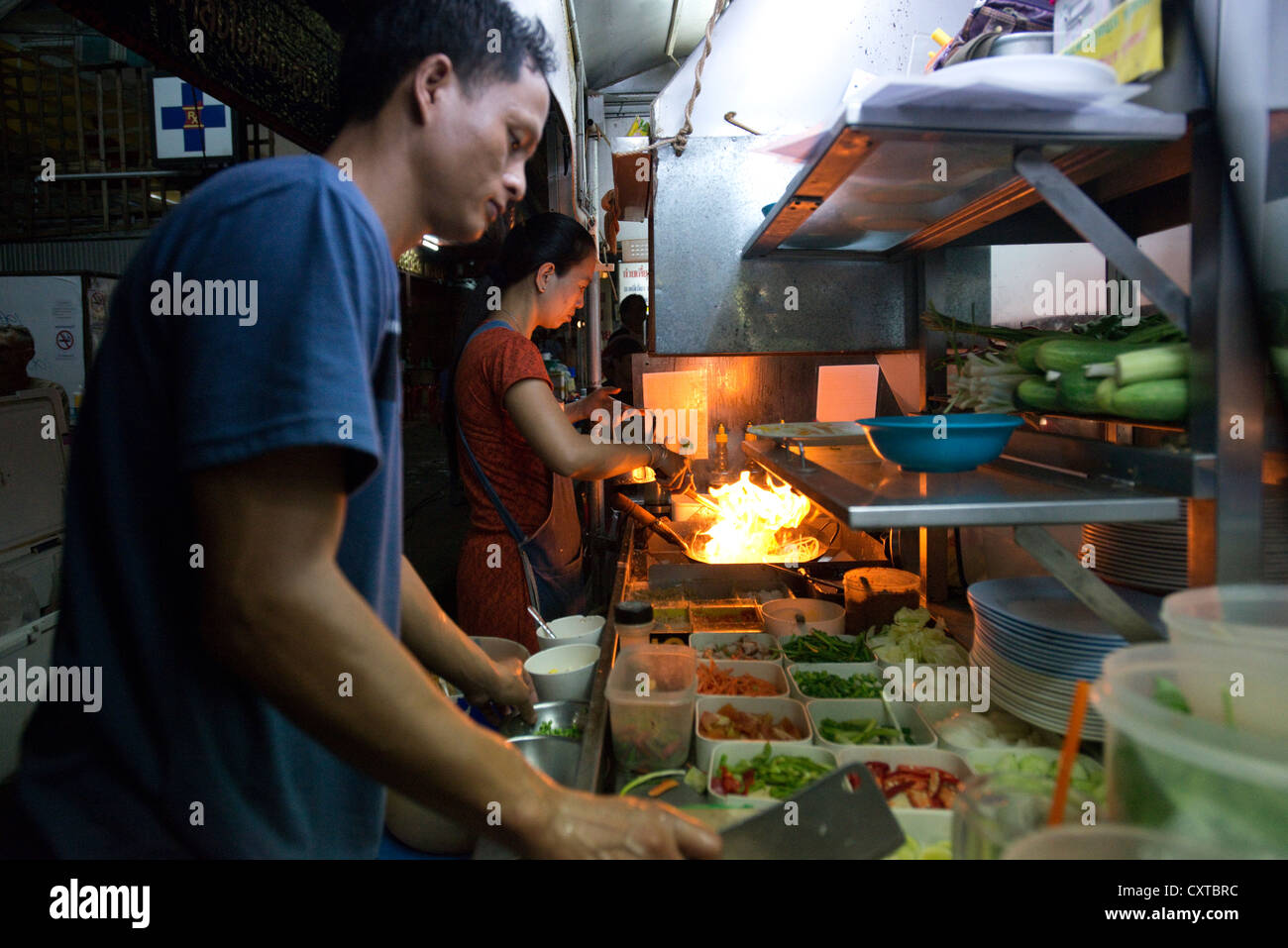 Un venditore ambulante prepara il cibo alla sua pressione di stallo in Chiang Mai Thailandia del Nord Foto Stock