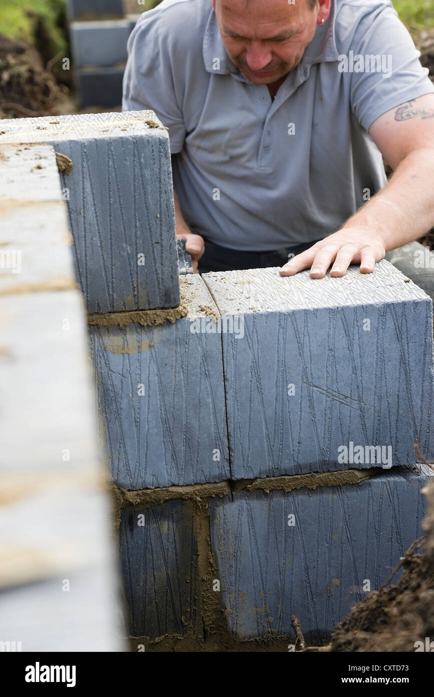 Workman usando una sega per tagliare il blocco in calcestruzzo su un Regno Unito sito in costruzione Foto Stock