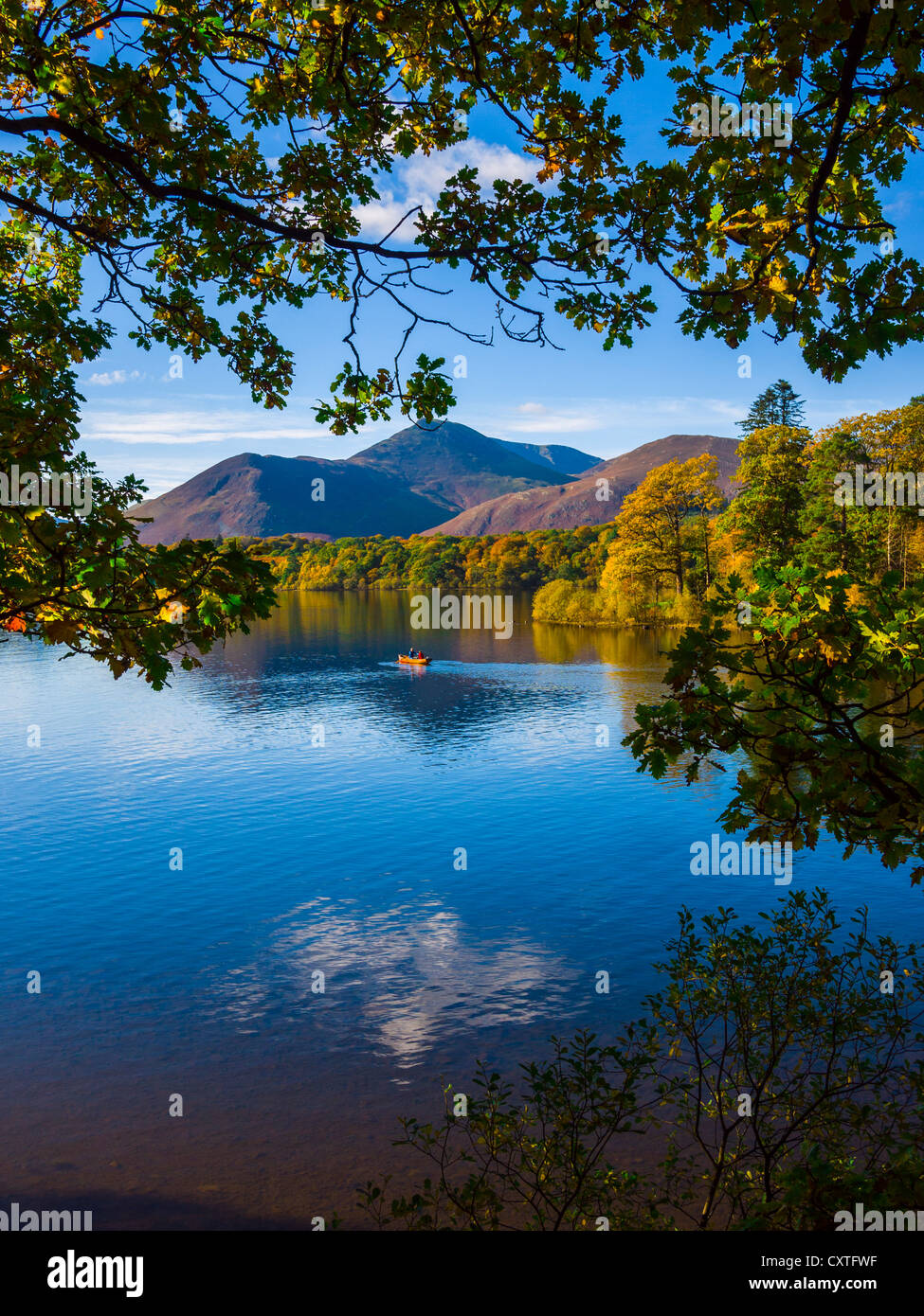 Due persone in una barca a remi sulle acque ferme dell'acqua di Derwent nel Lake District National Park. Keswick, Cumbria, Inghilterra. Foto Stock