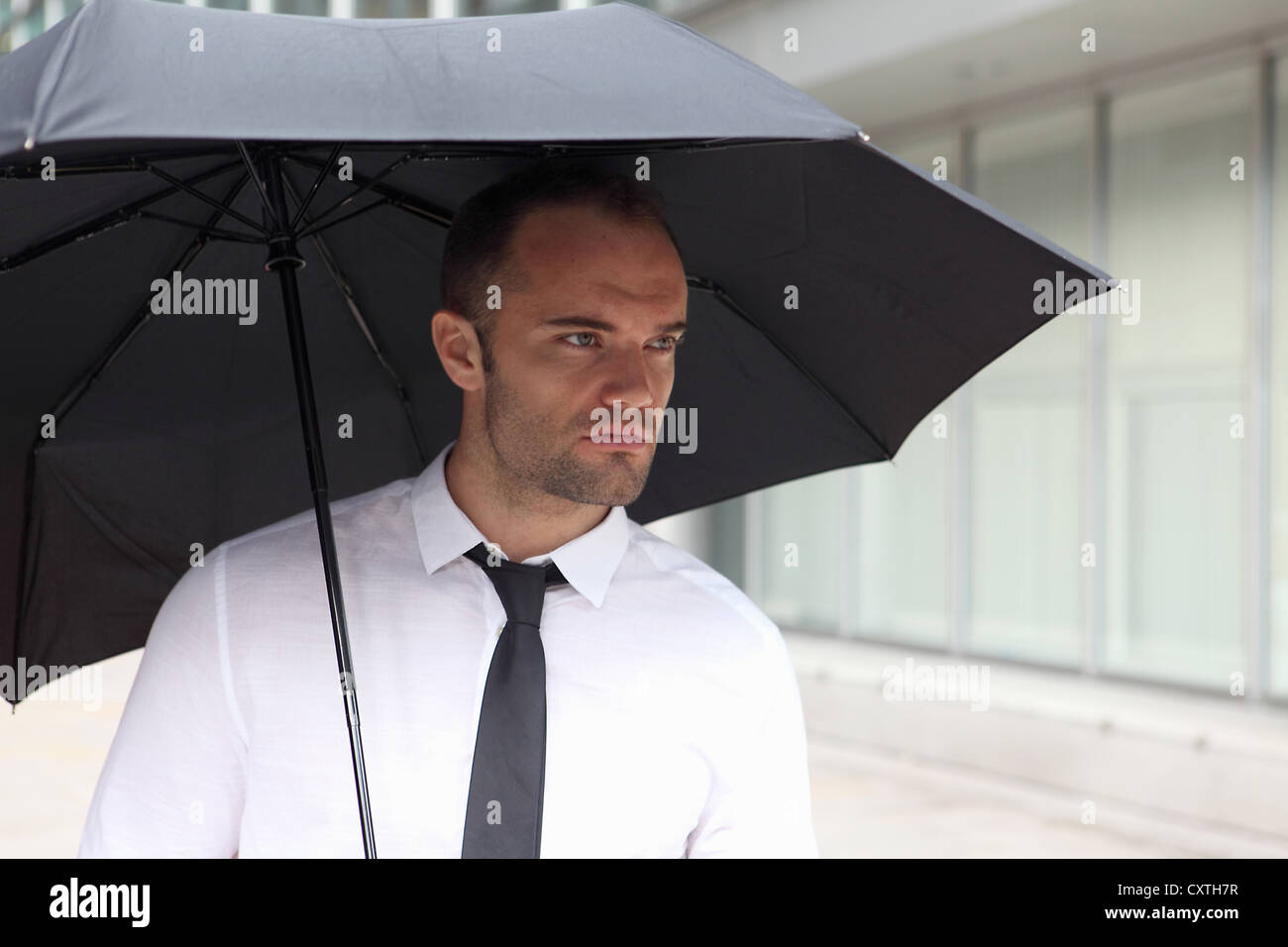 Imprenditore camminare sotto ombrellone Foto Stock
