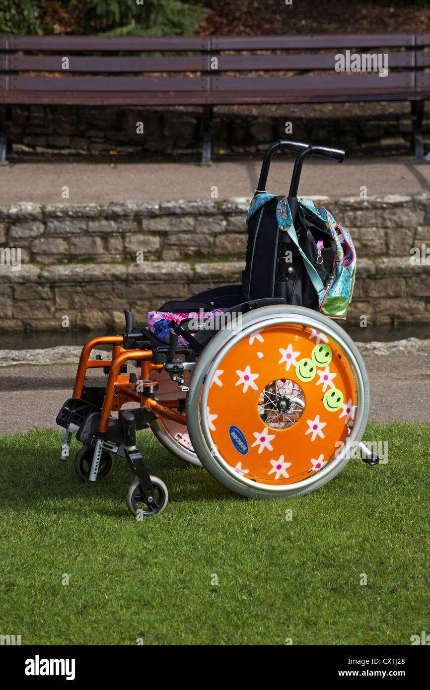 Sedia a rotelle vuota con vivacemente colorato di arancione ruote con  margherite e smiley adesivi su a Bournemouth giardini in Settembre Foto  stock - Alamy