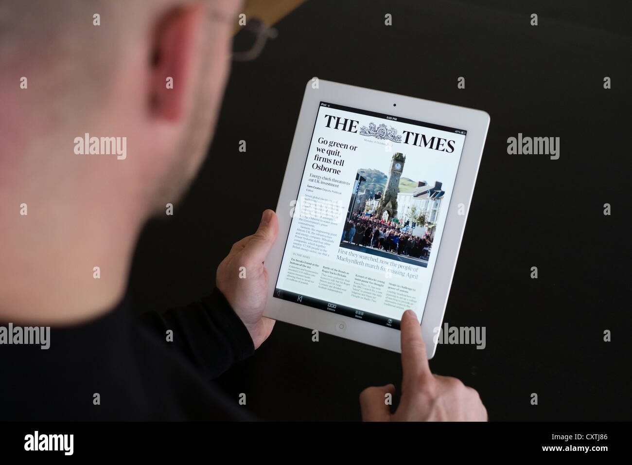 L'uomo la lettura online la versione mobile del Times su iPad3 computer tablet Foto Stock