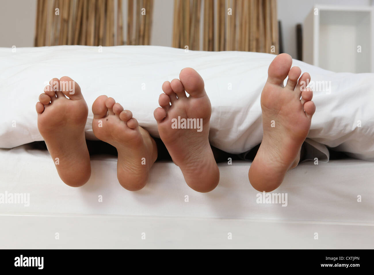 Maschio e femmina di piedi nel letto Foto Stock