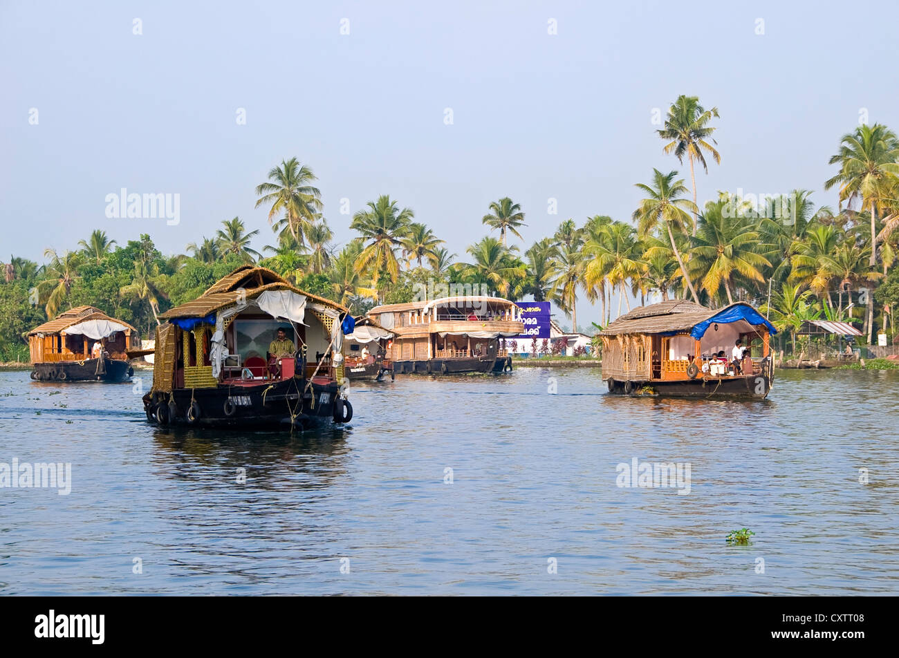 Vista orizzontale di molti tradizionale casa in legno barche, kettuvallams, vela attraverso le lagune del Kerala. Foto Stock