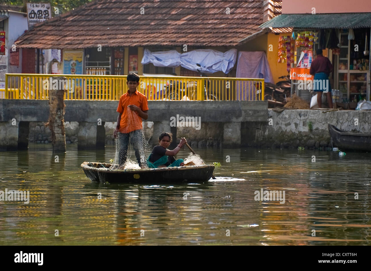 Vista orizzontale di un tradizionale appuntamento barca da pesca, parisal, con due persone di pesca sulle lagune del Kerala. Foto Stock