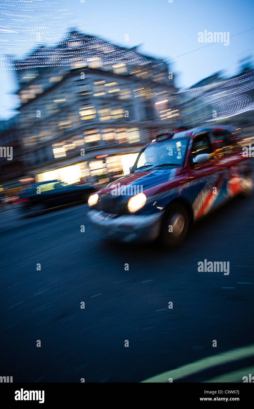 Taxi a Londra in movimento - Motion Blur colpo di London Black Cab in Unione Jack decor. Foto Stock