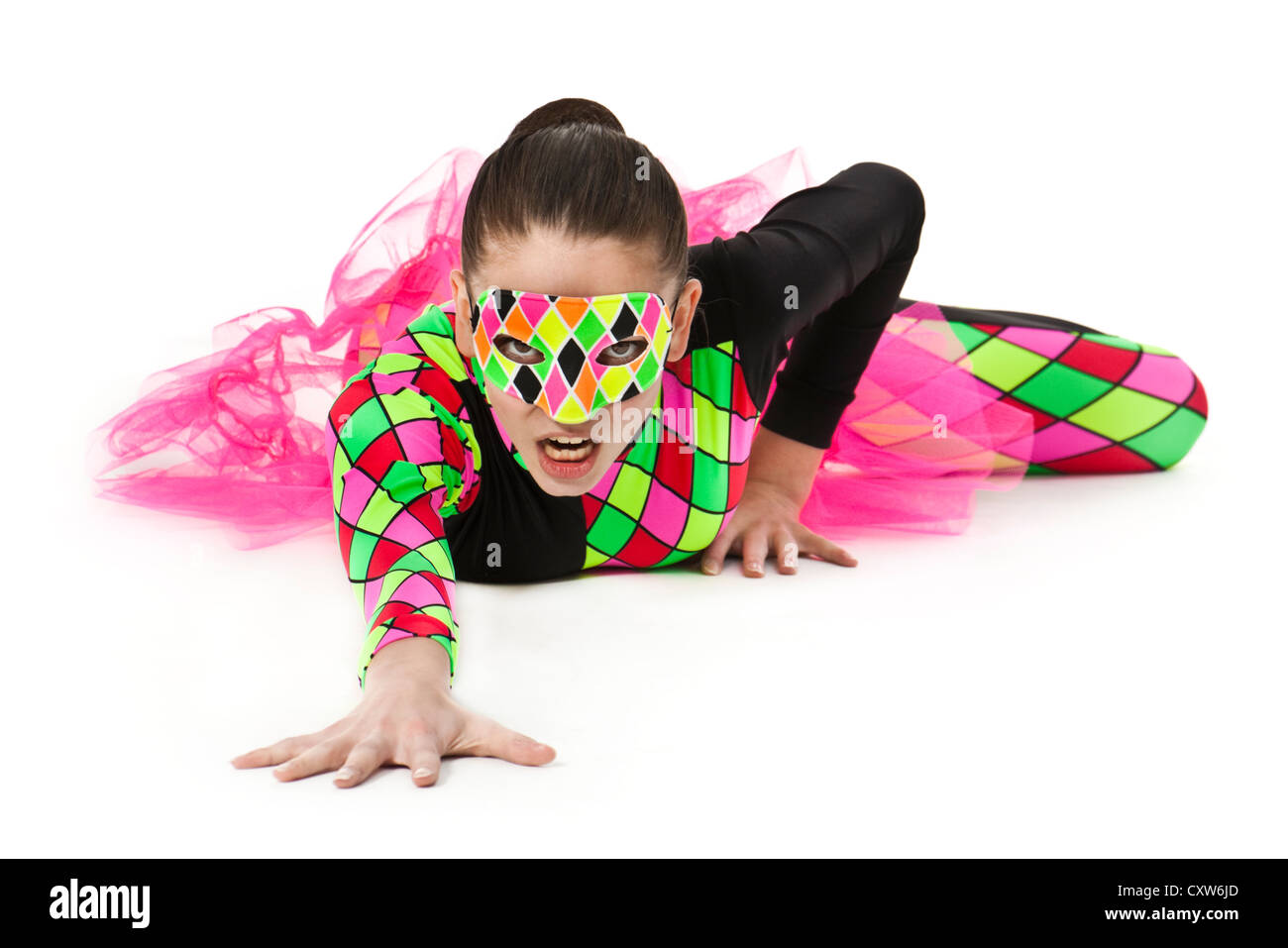 Ballerina adolescenti nei moderni multi-colore di arlecchino-pattern costume di balletto con compensazione rosa e indossa una corrispondente maschera facciale Foto Stock