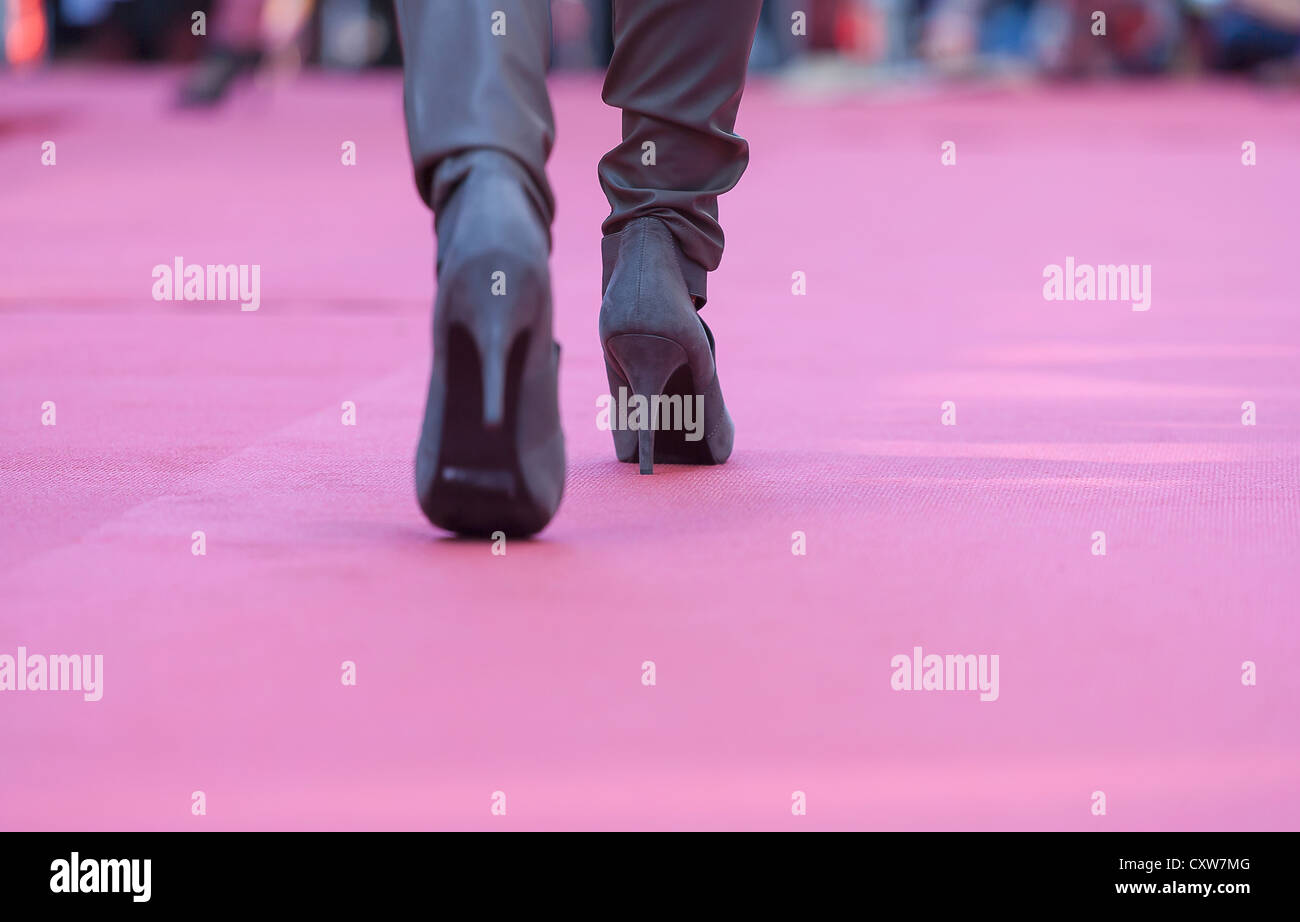 Donna con tacchi alti a camminare in una sfilata di moda Foto Stock