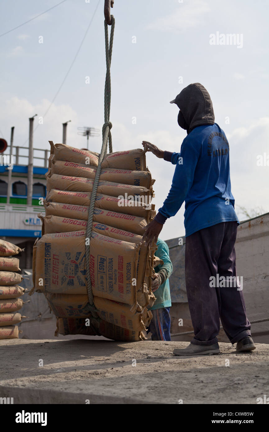 I lavoratori di scarico sacchi di cemento nel Porto di Sunda Kelapa a Jakarta, Indonesia Foto Stock