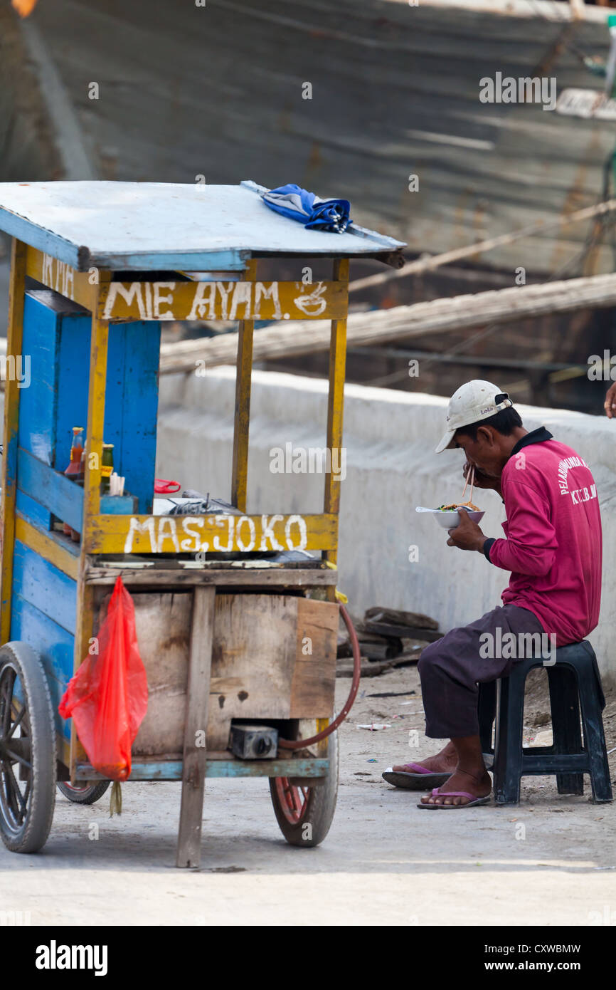 Lavoratore di mangiare nel Porto di Sunda Kepala in Giacarta Foto Stock