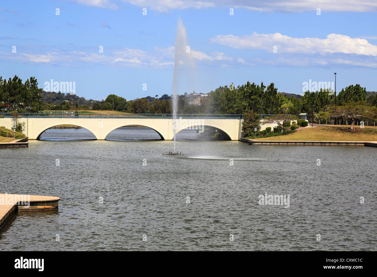 Ponte ad arco sul lago con la fontana in primo piano Foto Stock