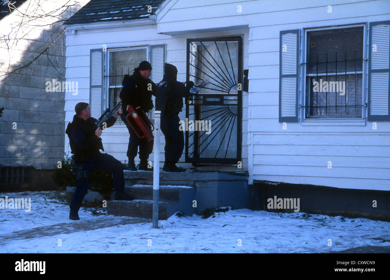 Narco ufficiali da Detroit del Dipartimento di Polizia di unità narcotici, forza entrata in un farmaco sospetto indirizzo. Foto Stock