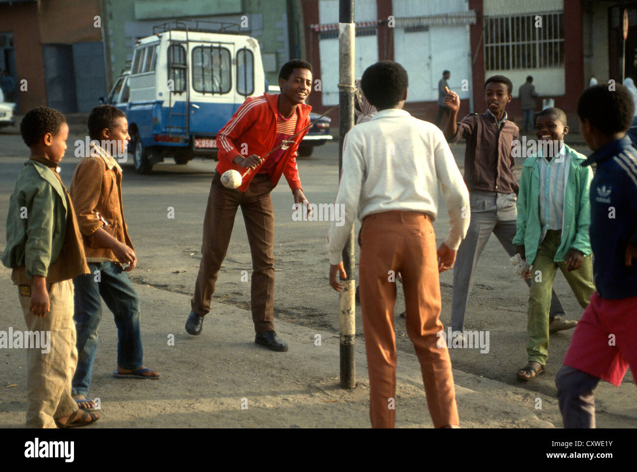 Ragazzi giocare una familiarità palla di gioco in corrispondenza di un lampione in strada- ad Addis Abeba in Etiopia in Africa orientale Foto Stock