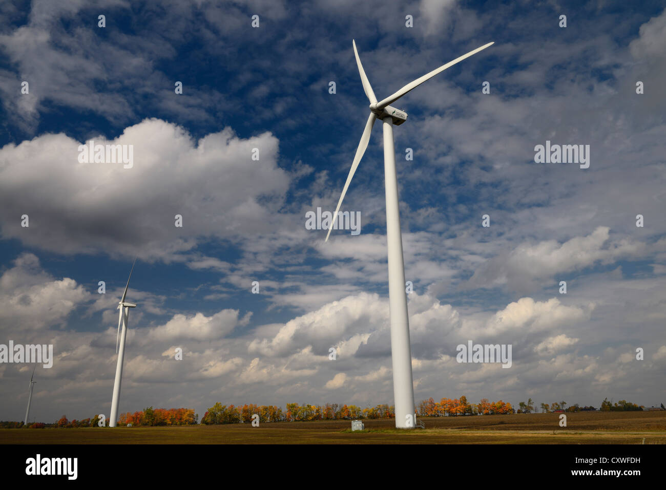 Il potere di vento turbine che generano elettricità sul campo di fattoria con nuvole bianche in autunno Dufferin Regione Ontario Canada Foto Stock