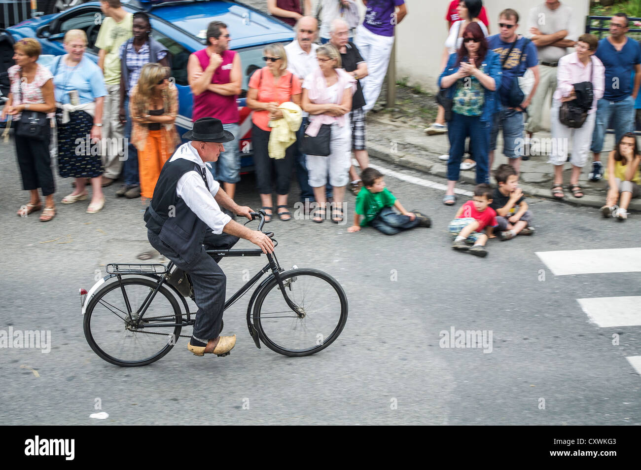 Uomo che indossa gli zoccoli mentre la bicicletta nell'Autrefois Le Couserons annuale-rurale vita parade San Girons, Midi-Pirenei, Francia Foto Stock