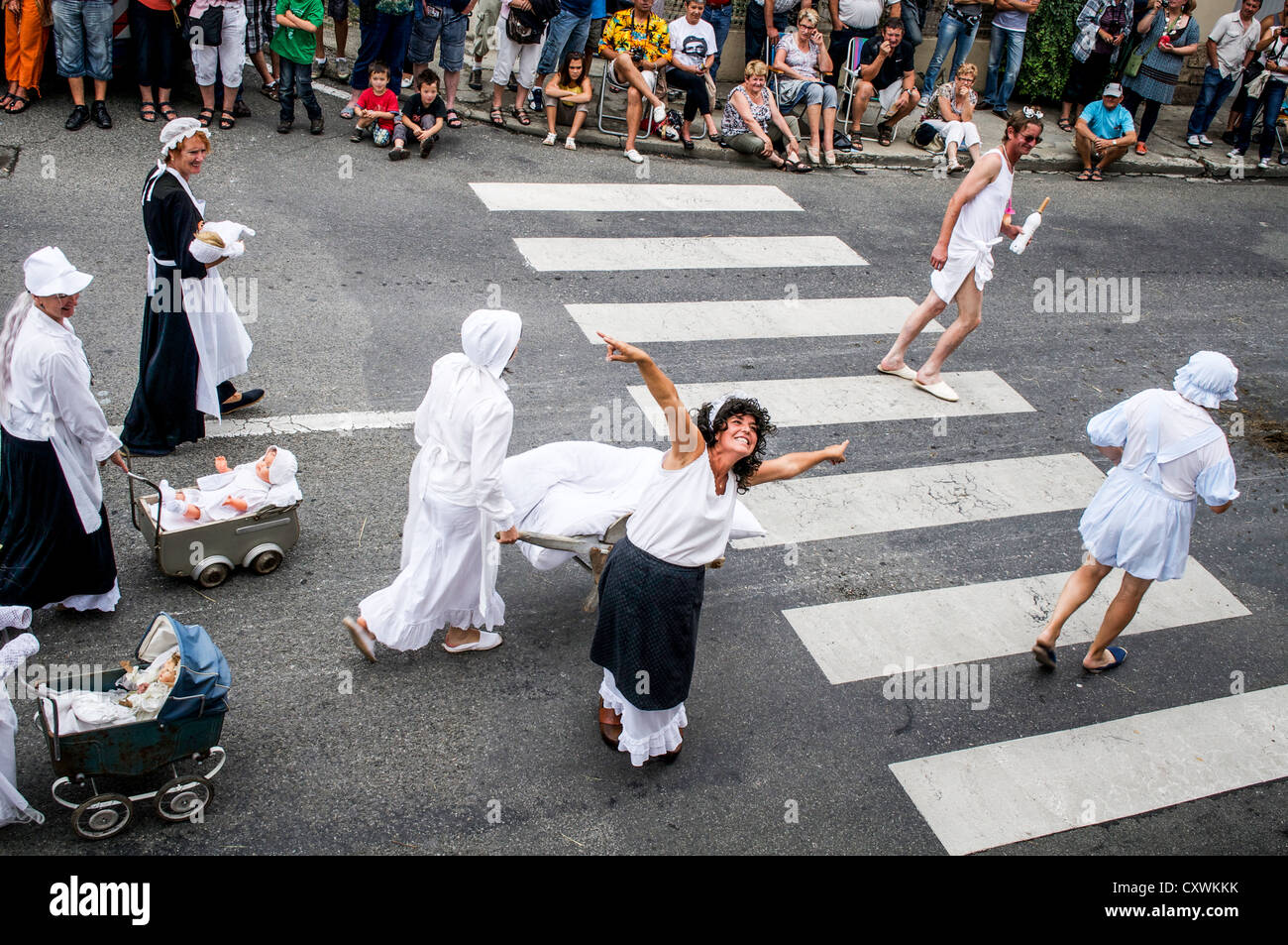 Cantando e ballando esecutori vestita come la maternità infermieri e neonati a Autrefois Le Couserons parade, San GIRONS, Francia. Foto Stock