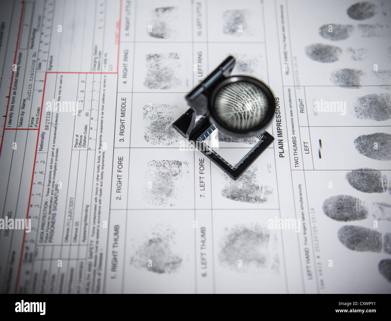 Loupe sopra le impronte digitali sul modulo di arresto Foto Stock