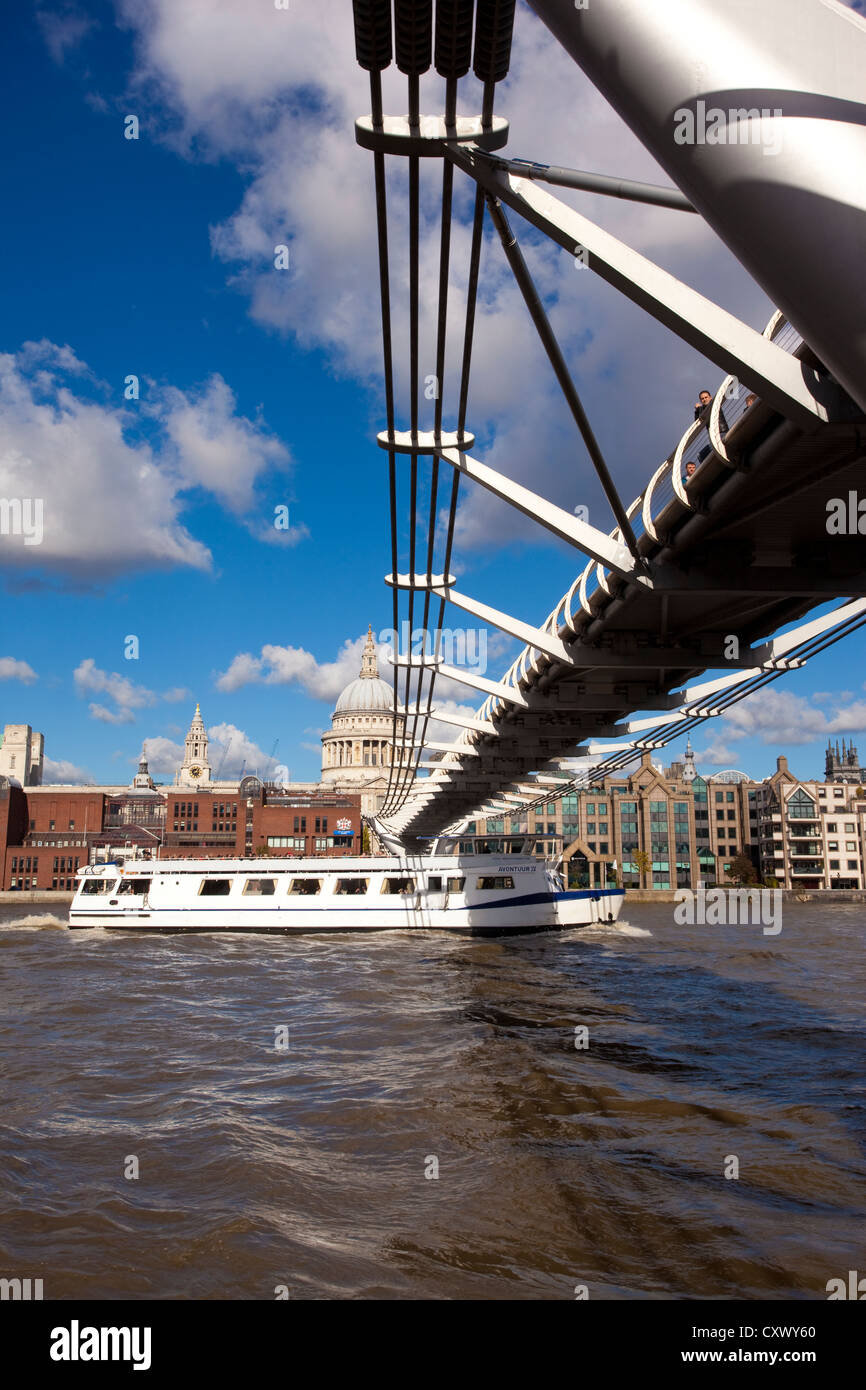 Battello da crociera sul Fiume Tamigi passa sotto il Millennium Bridge, con la Cattedrale di St Paul e nella distanza, London, England Regno Unito Foto Stock