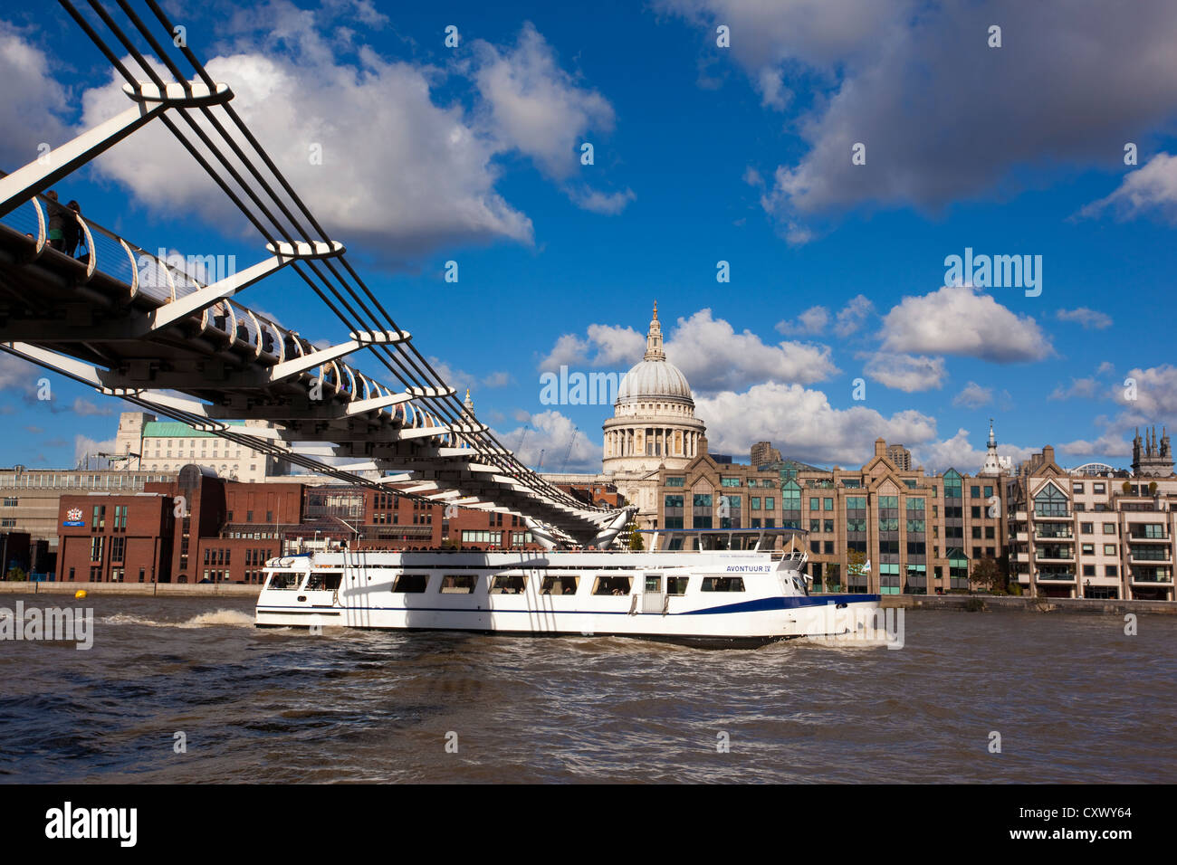 Battello da crociera sul Fiume Tamigi passa sotto il Millennium Bridge, con la Cattedrale di St Paul e nella distanza, London, England Regno Unito Foto Stock