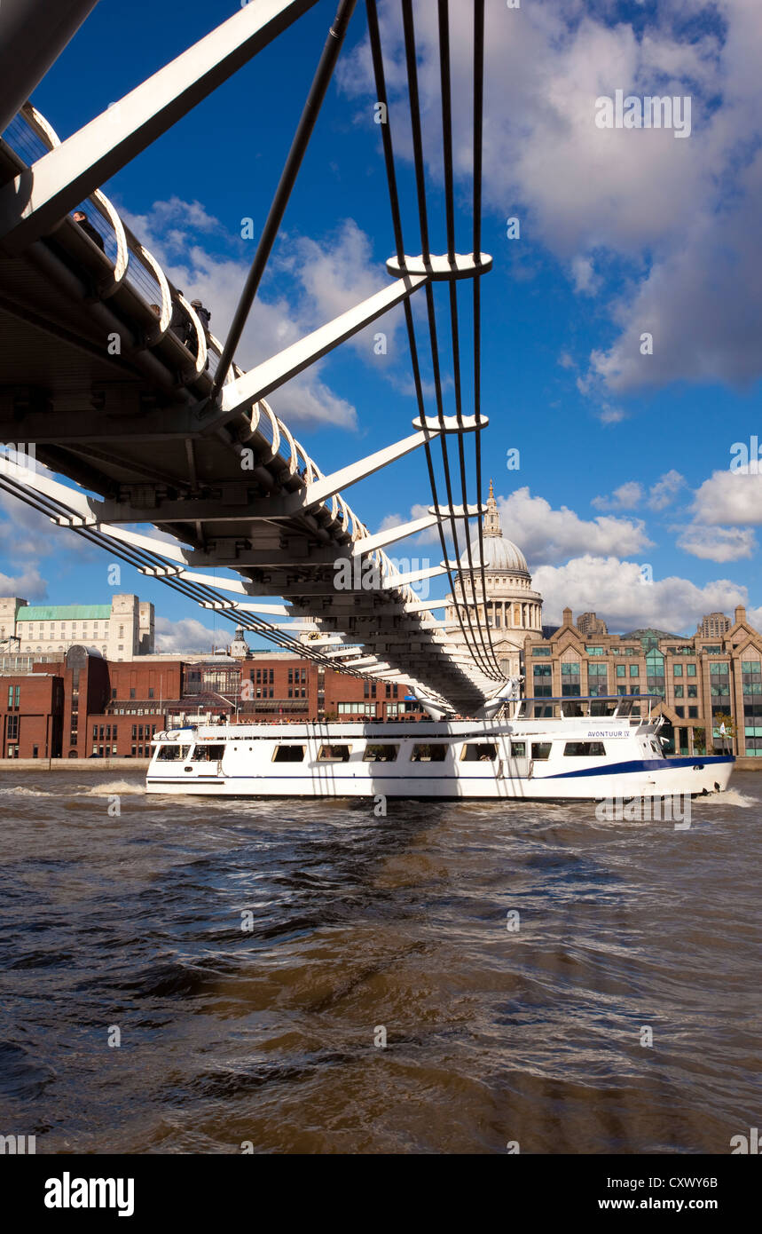 Battello da crociera sul Fiume Tamigi passa sotto il Millennium Bridge, con la Cattedrale di St Paul e nella distanza, London, England Regno Unito Foto Stock