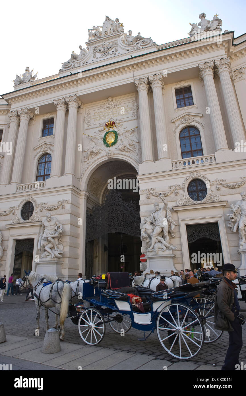 Tradizionale carrozza trainata da cavalli e conducente al di fuori del Palazzo Imperiale Hofburg di Vienna, Austria Foto Stock