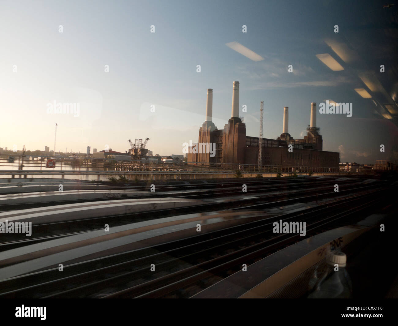 Battersea Power Station e sfocata binari vista attraverso la finestra all'interno di un treno Gatwick Express il trasporto in London, England Regno Unito KATHY DEWITT Foto Stock