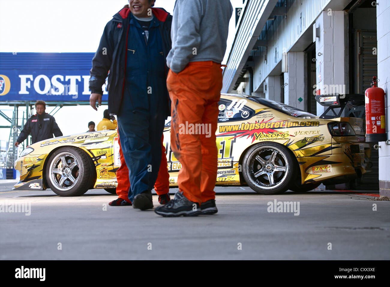 Gara di guida auto al di fuori del garage in pit lane Foto Stock