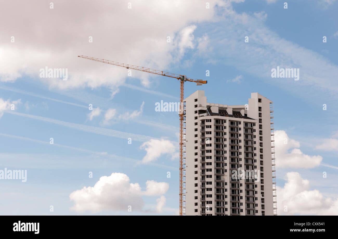 La costruzione di un grattacielo. Chemtrails nel cielo. Foto Stock