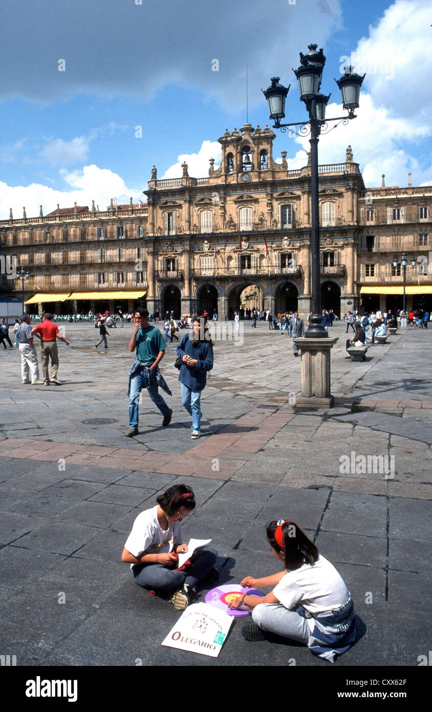 Due ragazze giovani seduti a terra in Plaza Mayor Salamanca spagna Foto Stock