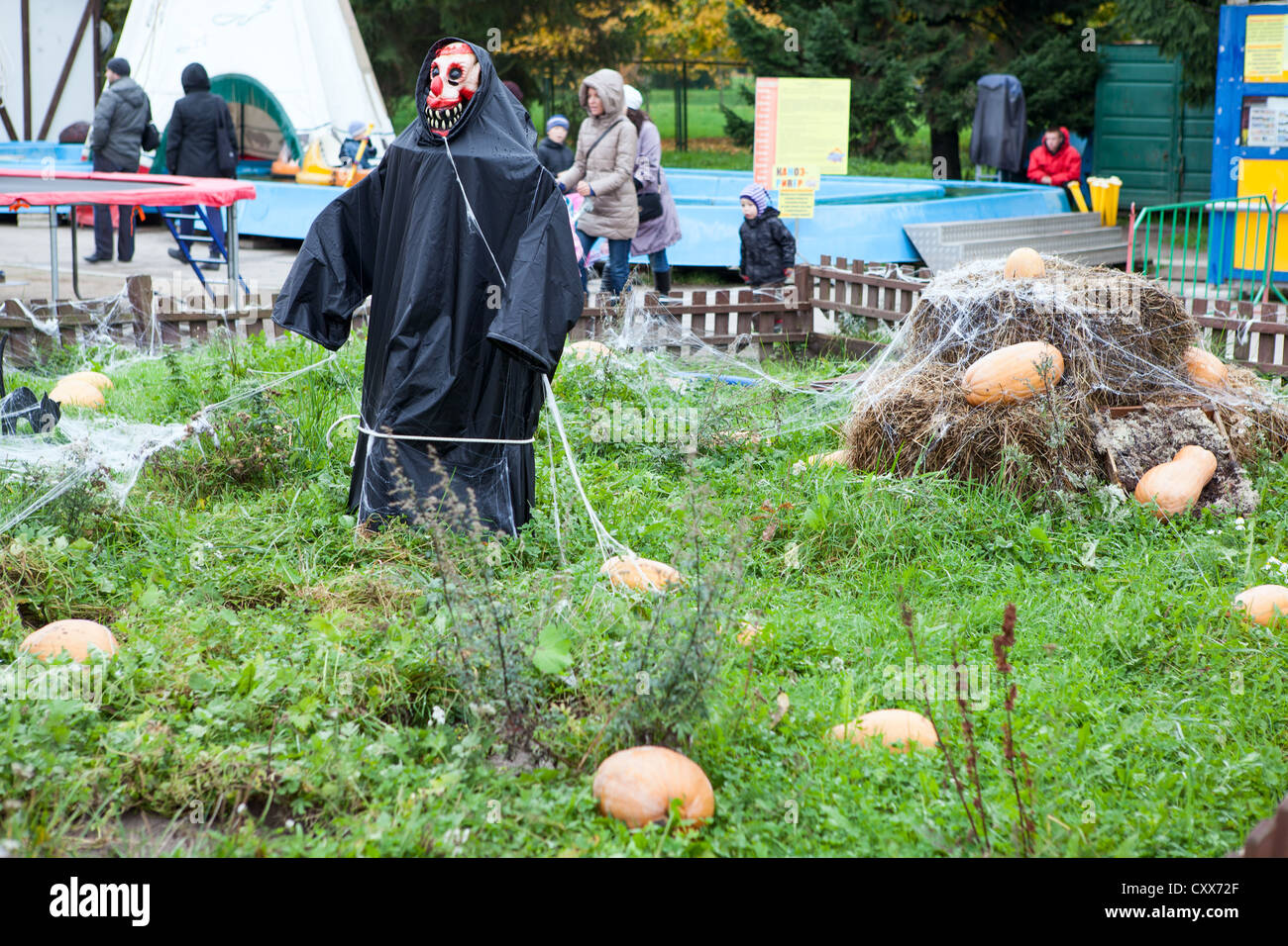 Lo Spaventapasseri in manto nero si erge nel mezzo del parco divertimenti in Russia. Decorazioni di Halloween Foto Stock