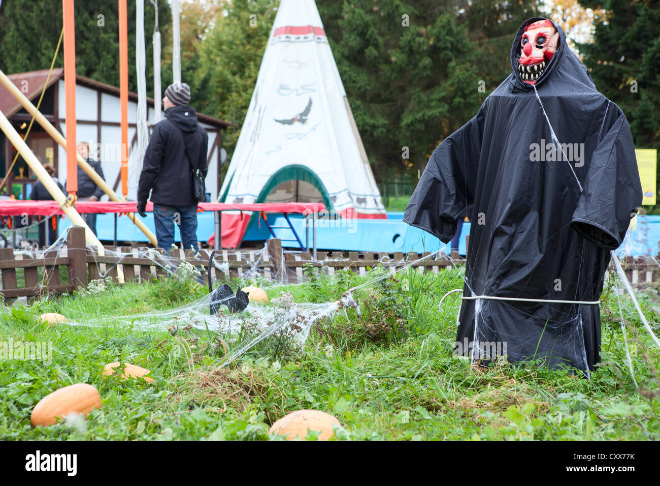 Lo Spaventapasseri in manto nero si erge nel mezzo del giardino nel parco di divertimenti. Decorazioni di Halloween. San Pietroburgo, Russia Foto Stock