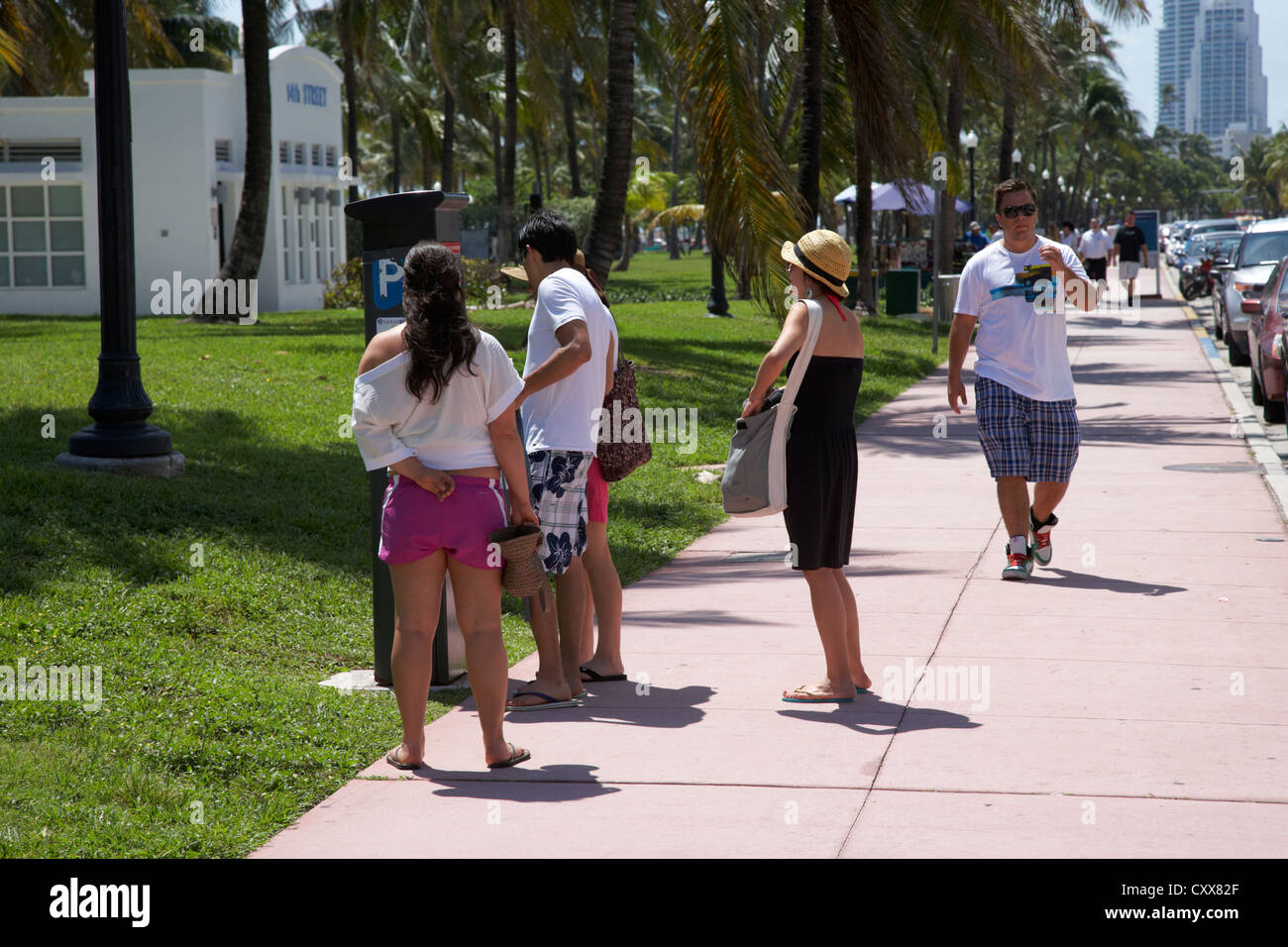 Persone disposte a pagare in biglietti per il parcheggio macchina ocean drive la mattina presto dal quartiere art déco di Miami South beach florida usa Foto Stock