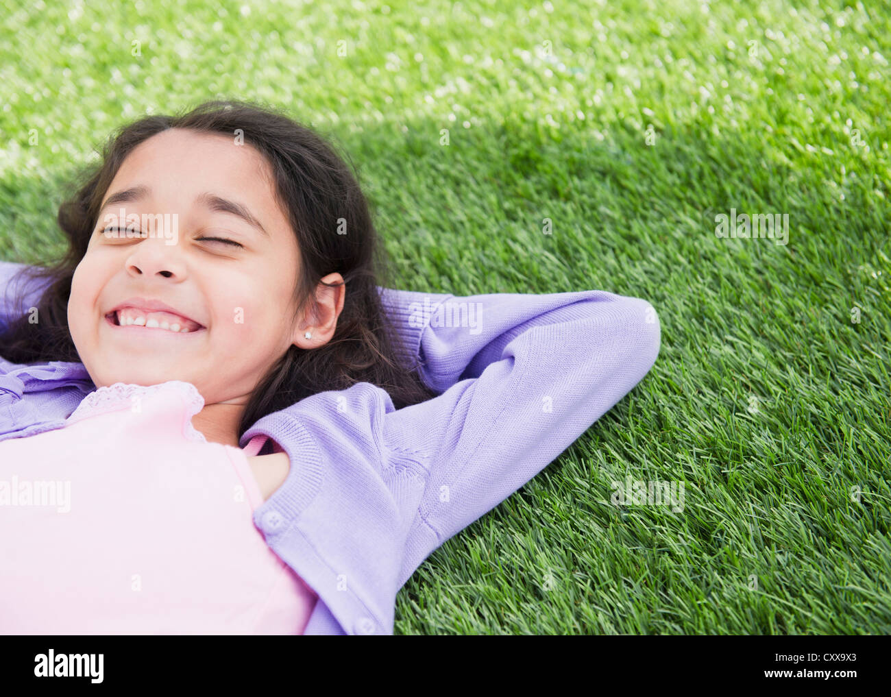 Razza mista ragazza posa in erba Foto Stock