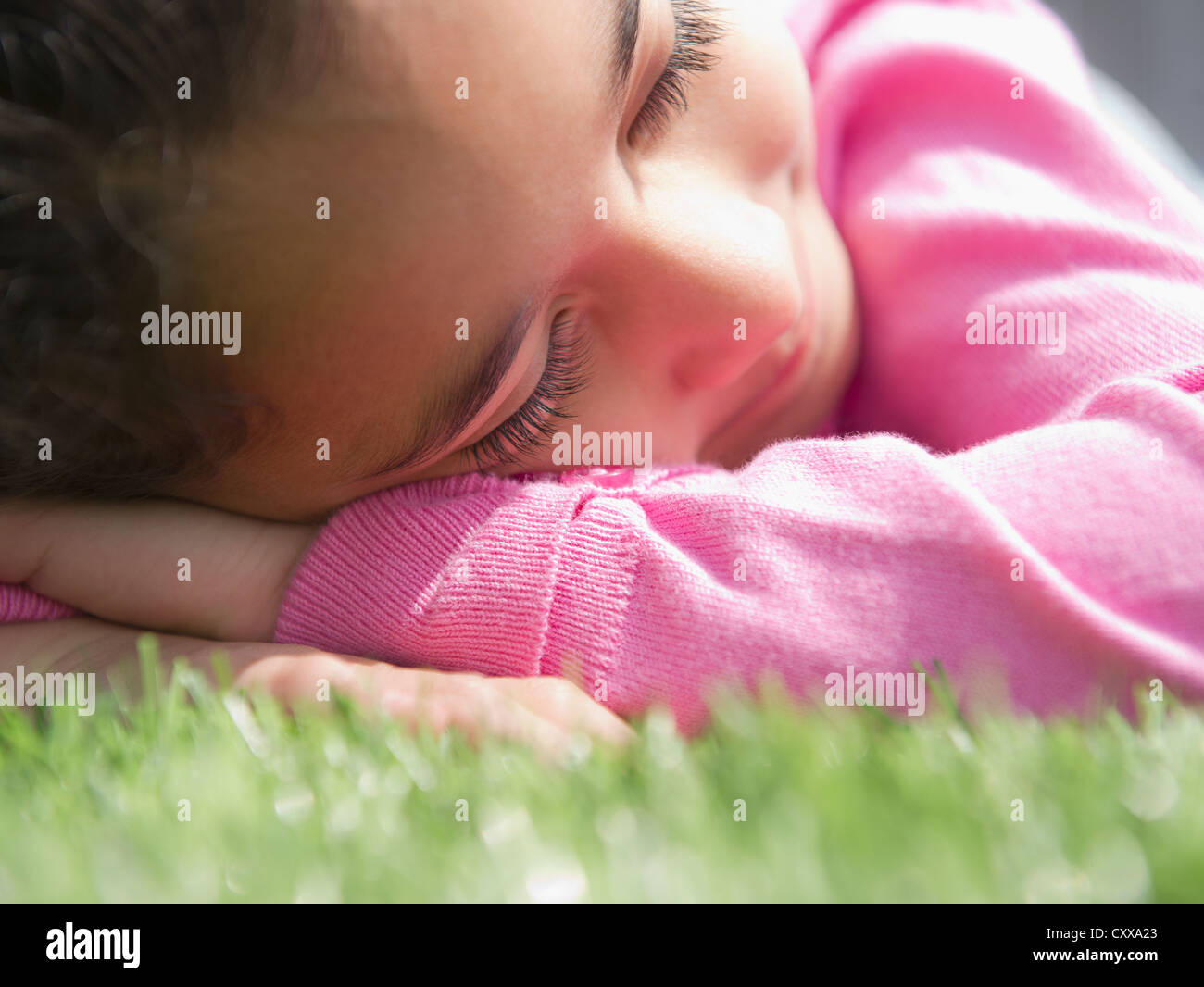 Razza mista ragazza dorme in erba Foto Stock